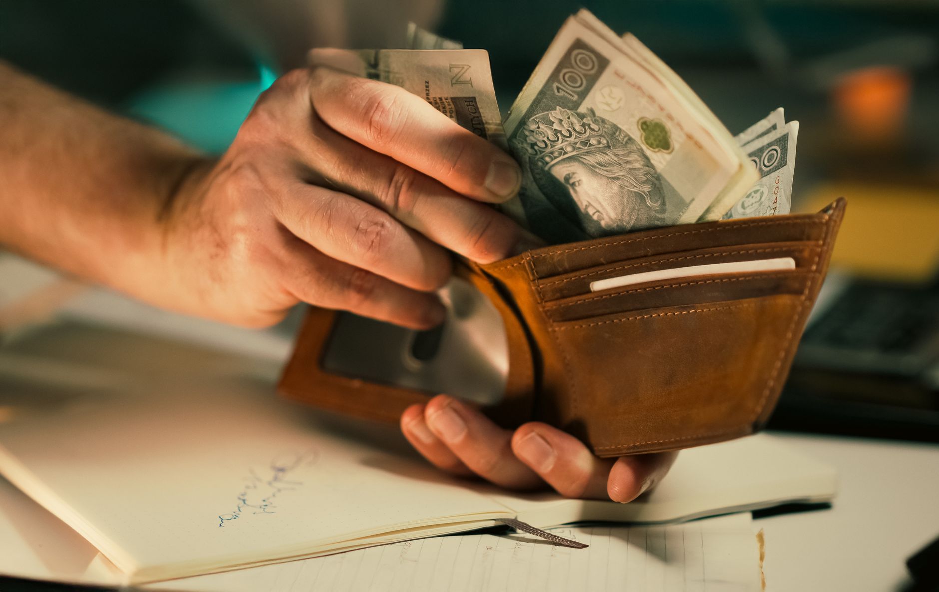 counting currency in a leather wallet